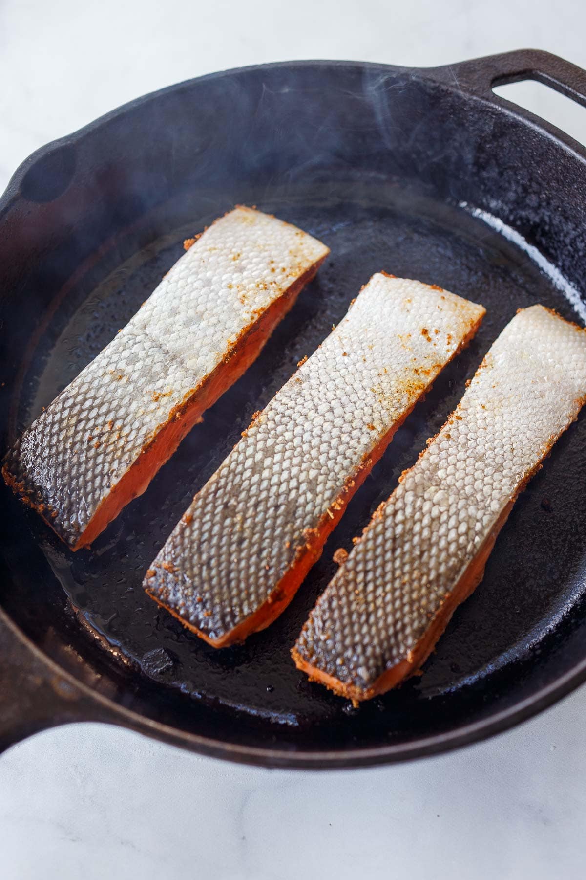 salmon filets skin side up in a cast iron skillet.