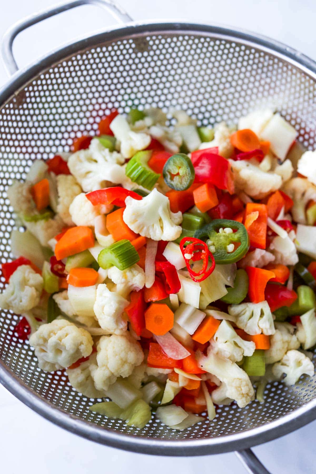 colander with giardiniera veggies - cauliflower, carrots, celery, peppers. 