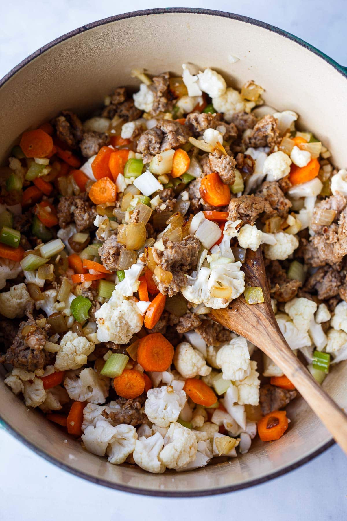 large pot with chopped veggies, carrots, celery, cauliflower, added to sautéed onions and ground turkey sausage.