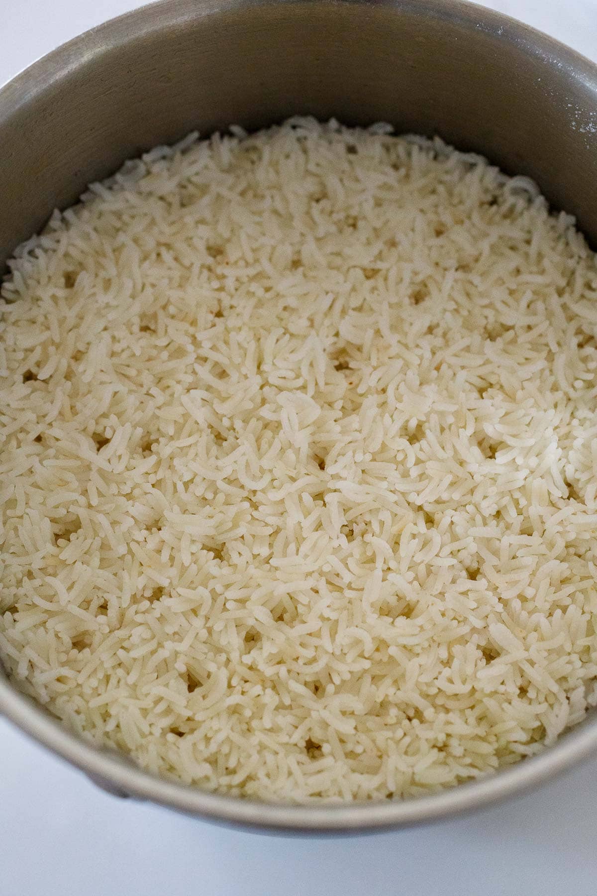 large pot with steamed basmati rice with steam pockets. 