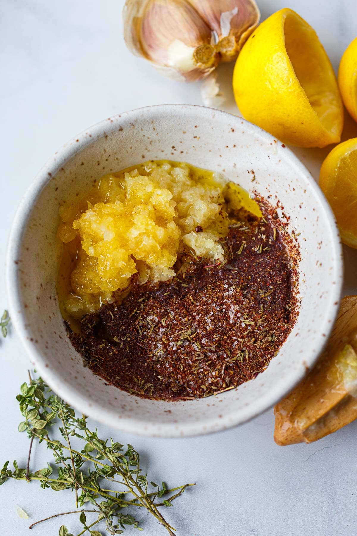 bowl of marinade ingredients - lemon, garlic, and spices.