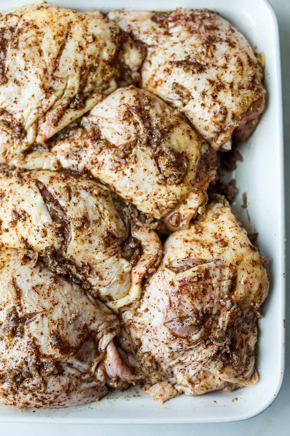 Chicken thighs rubbed with marinade.
