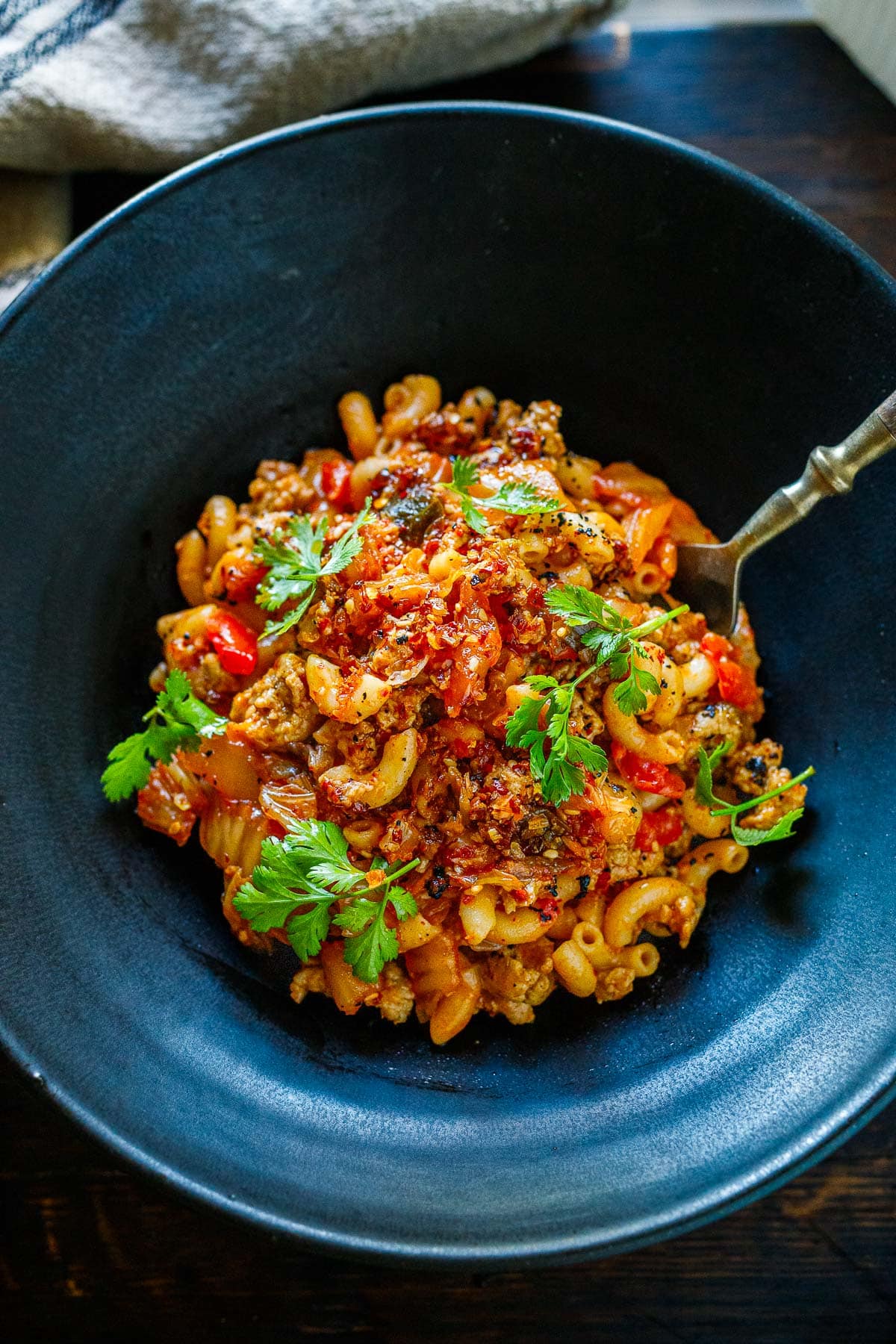 top view of bowl of kimchi chili mac and cheese garnished with cilantro. 