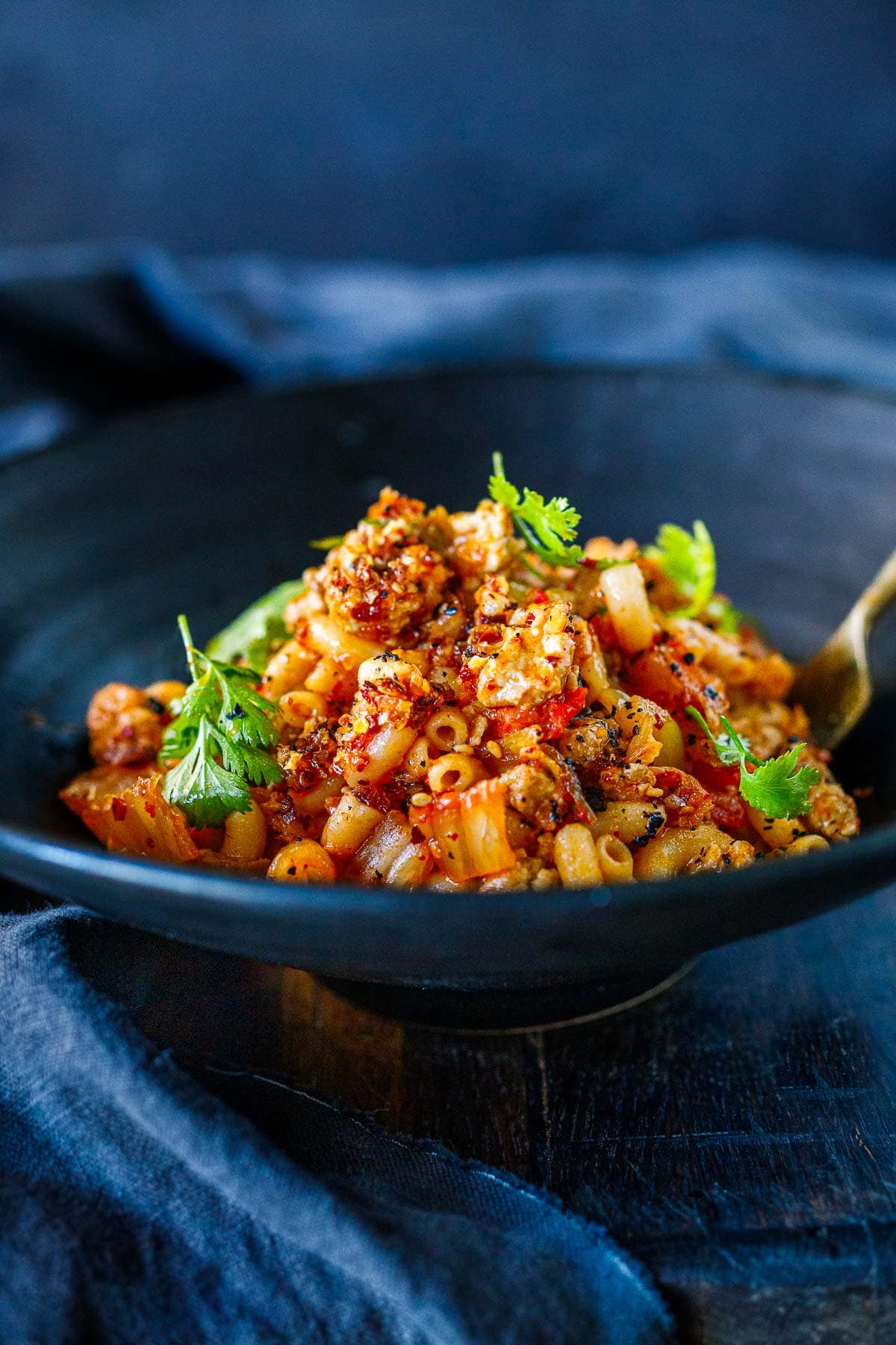 large bowl of kimchi chili mac and cheese garnished with cilantro.