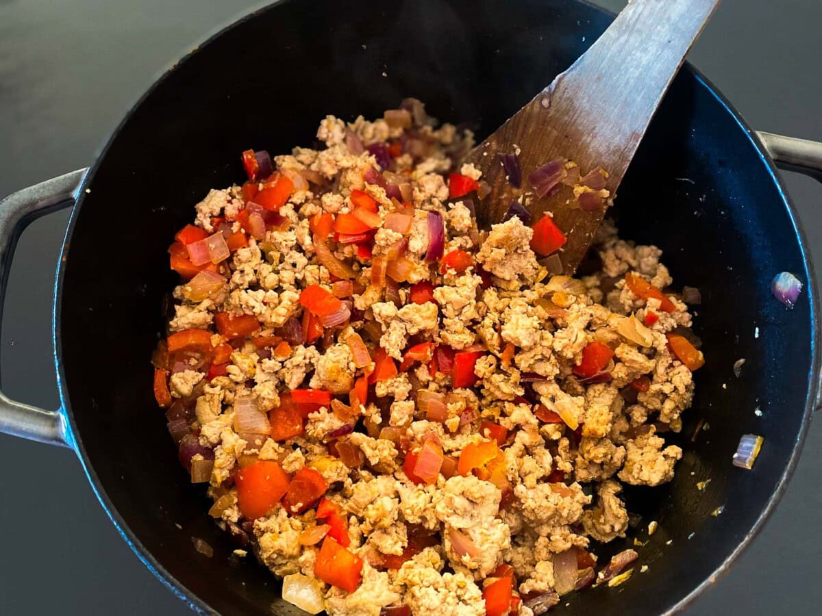 pot with cooked ground turkey and sautéed peppers and onions. 