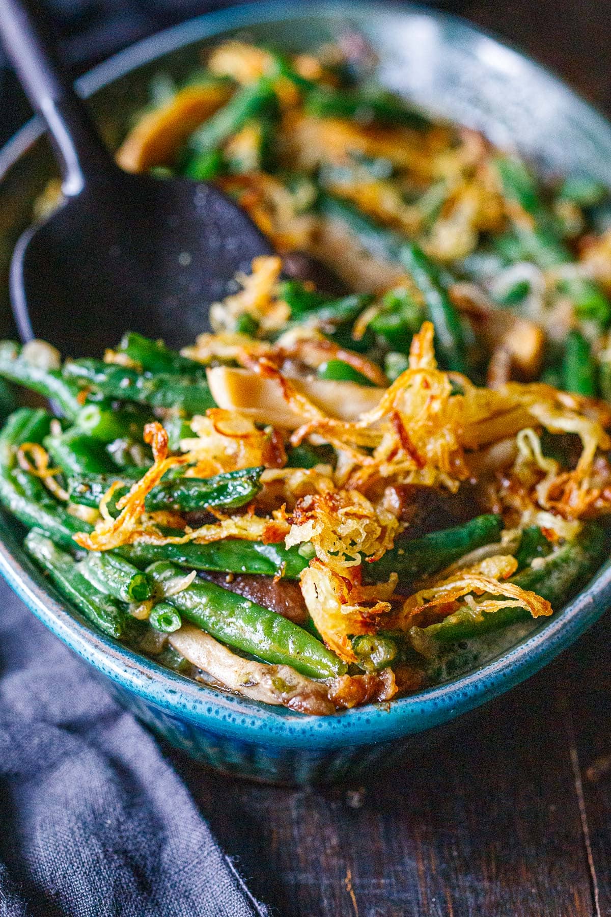 close up of green bean casserole with mushrooms and crispy onion topping.