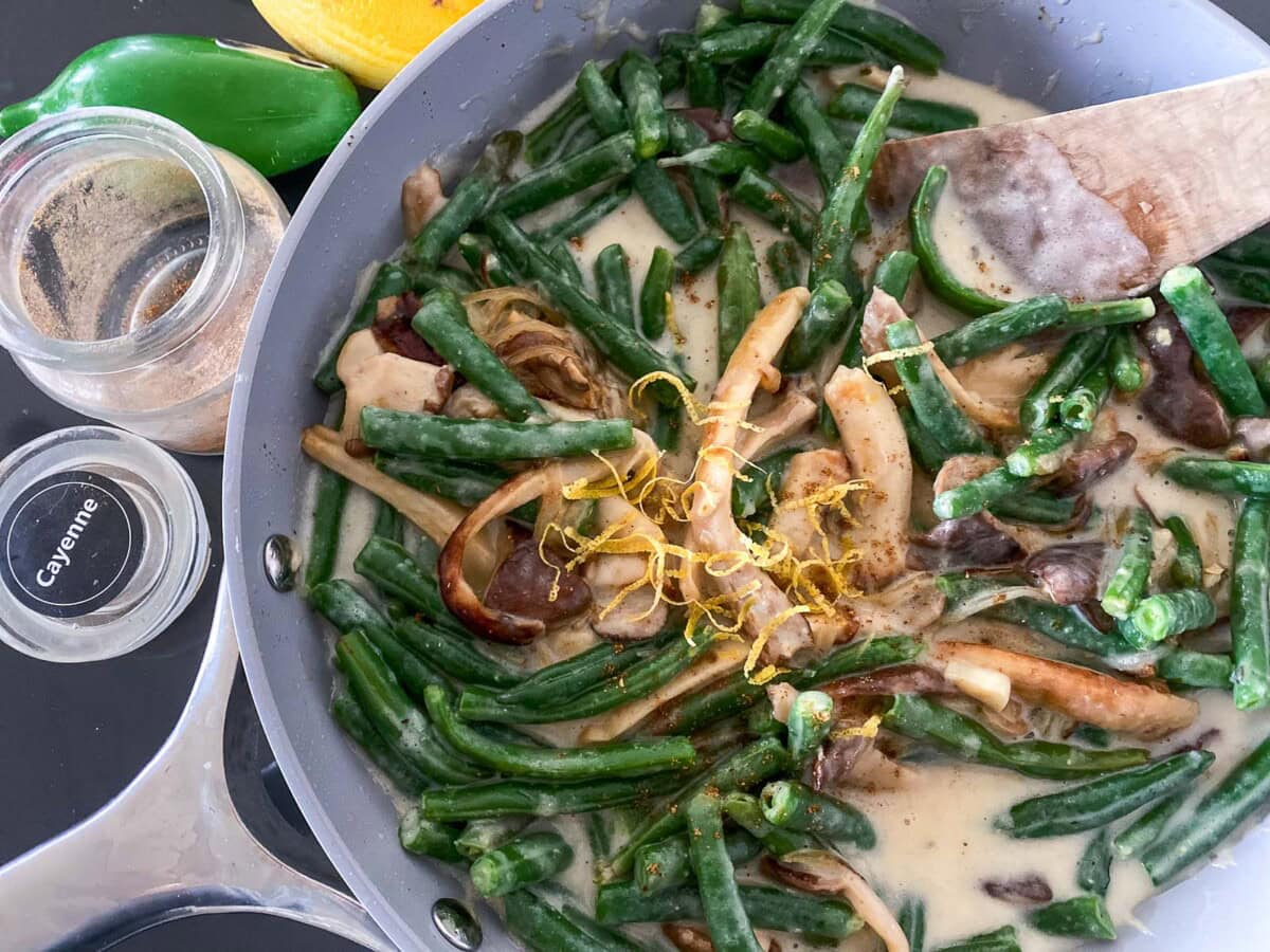 skillet with green beans and mushroom gravy with lemon zest.