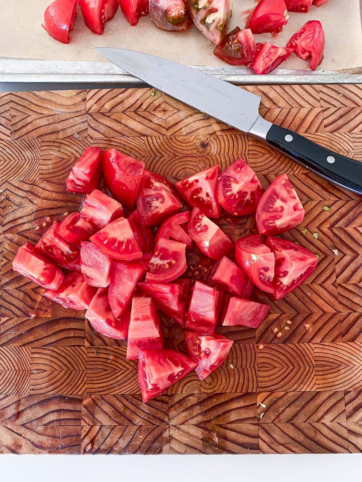 wood board and sharp knife with chopped tomatoes.