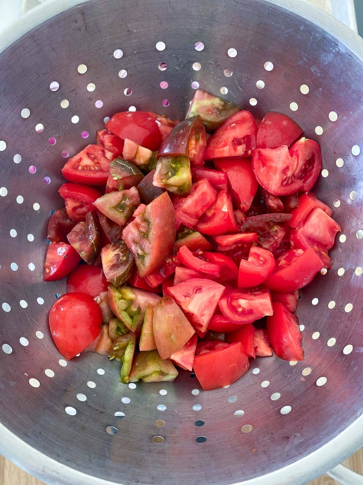 colander with chopped and salted tomatoes.