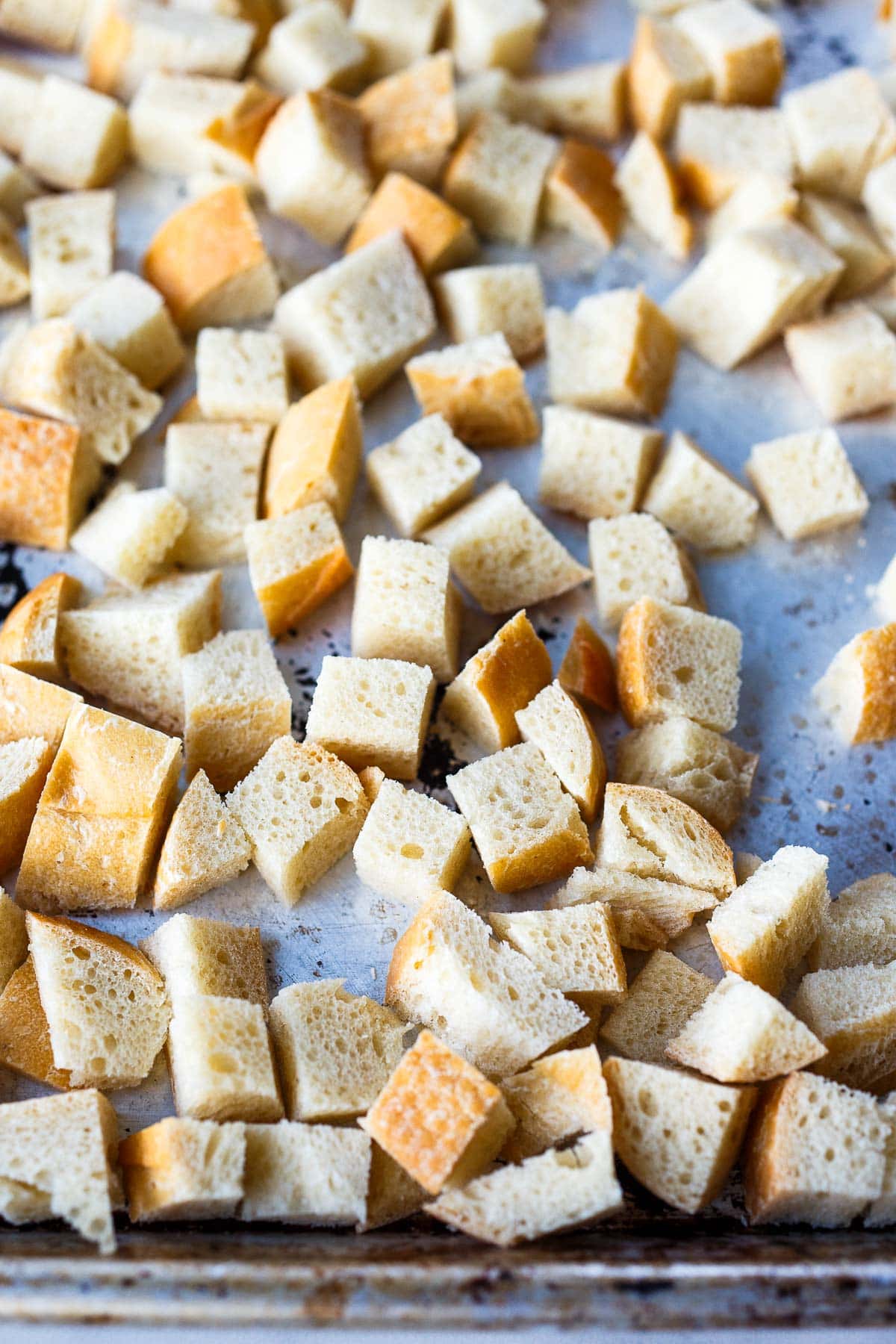 Bread cubes on a baking sheet.
