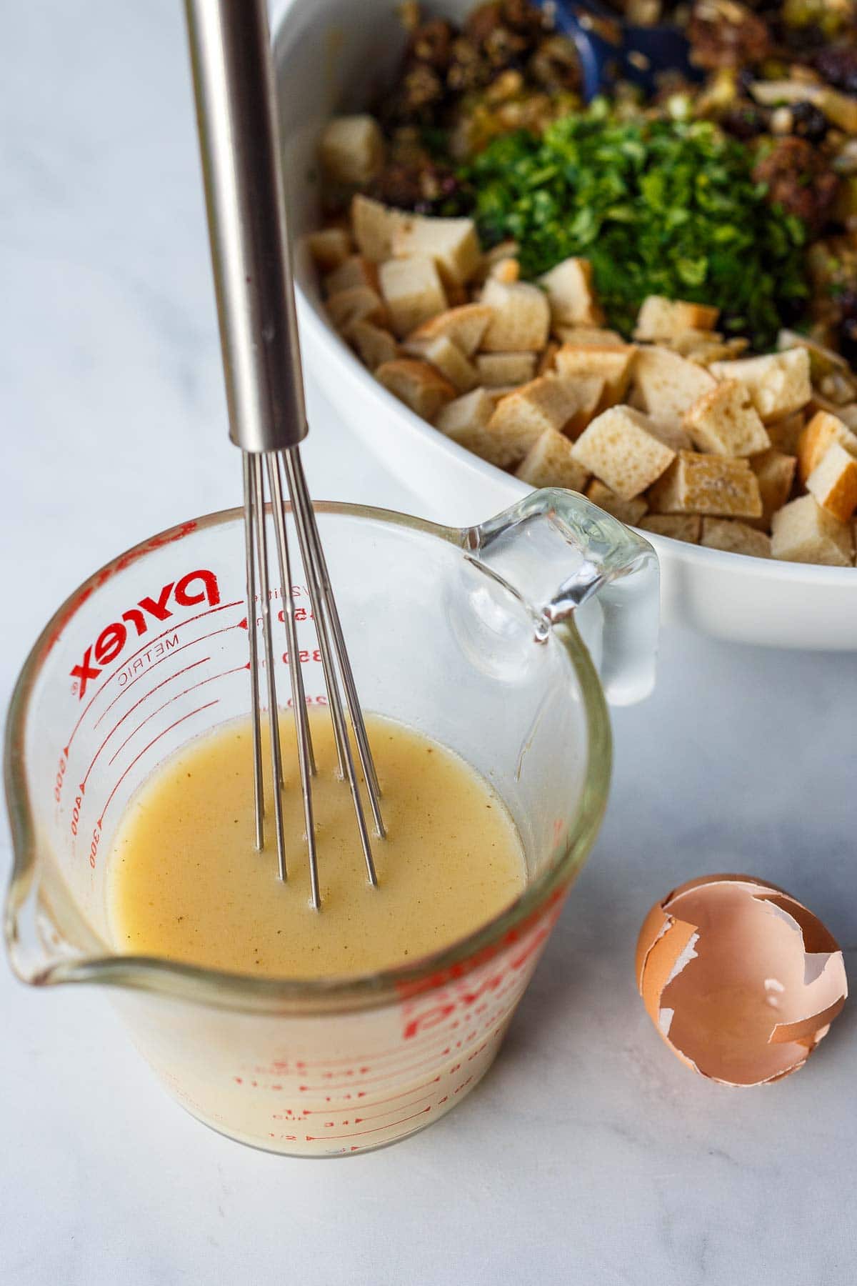 Egg and broth in a pyrex measuring cup.