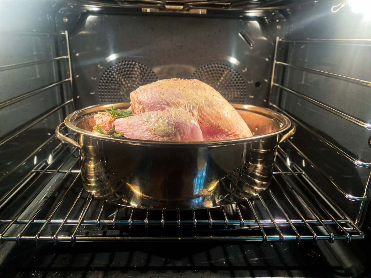 prepped turkey in roasting pan in the oven ready to bake.