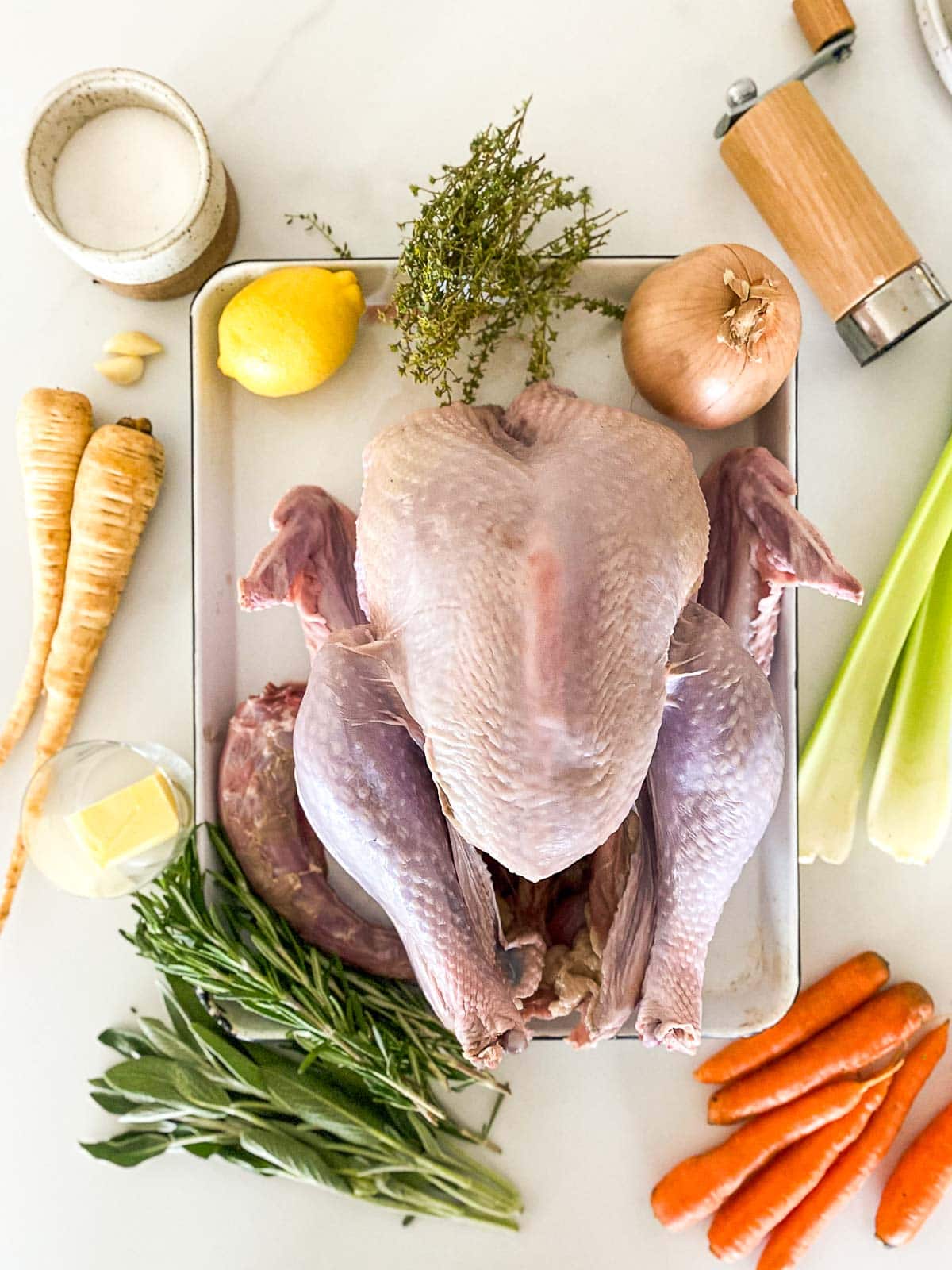 ingredients for roast turkey - turkey, onion, lemon, herbs, vegetables, garlic, butter, salt, and pepper.