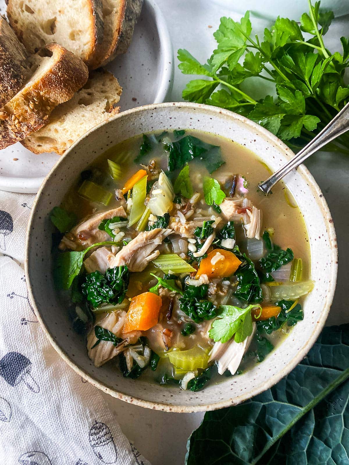 bowl of turkey rice soup with carrots, celery, and lacinato.