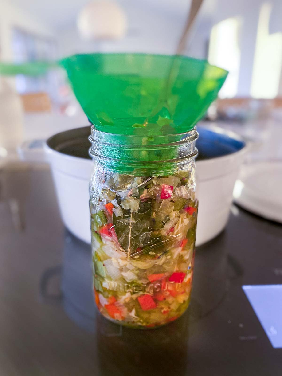 large jar with funnel packed with chow chow. 