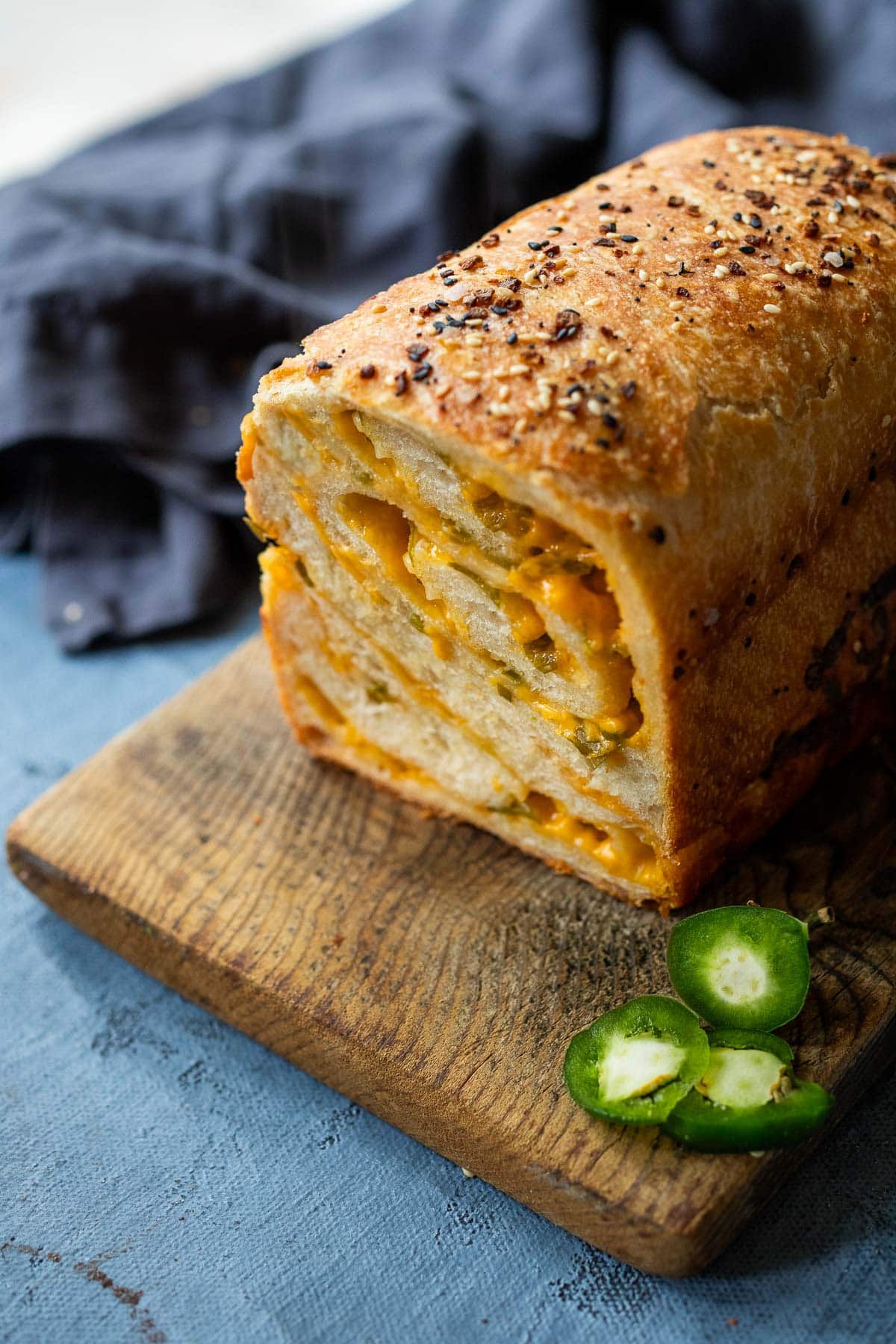 loaf of jalapeno cheddar sourdough on wood serving board.