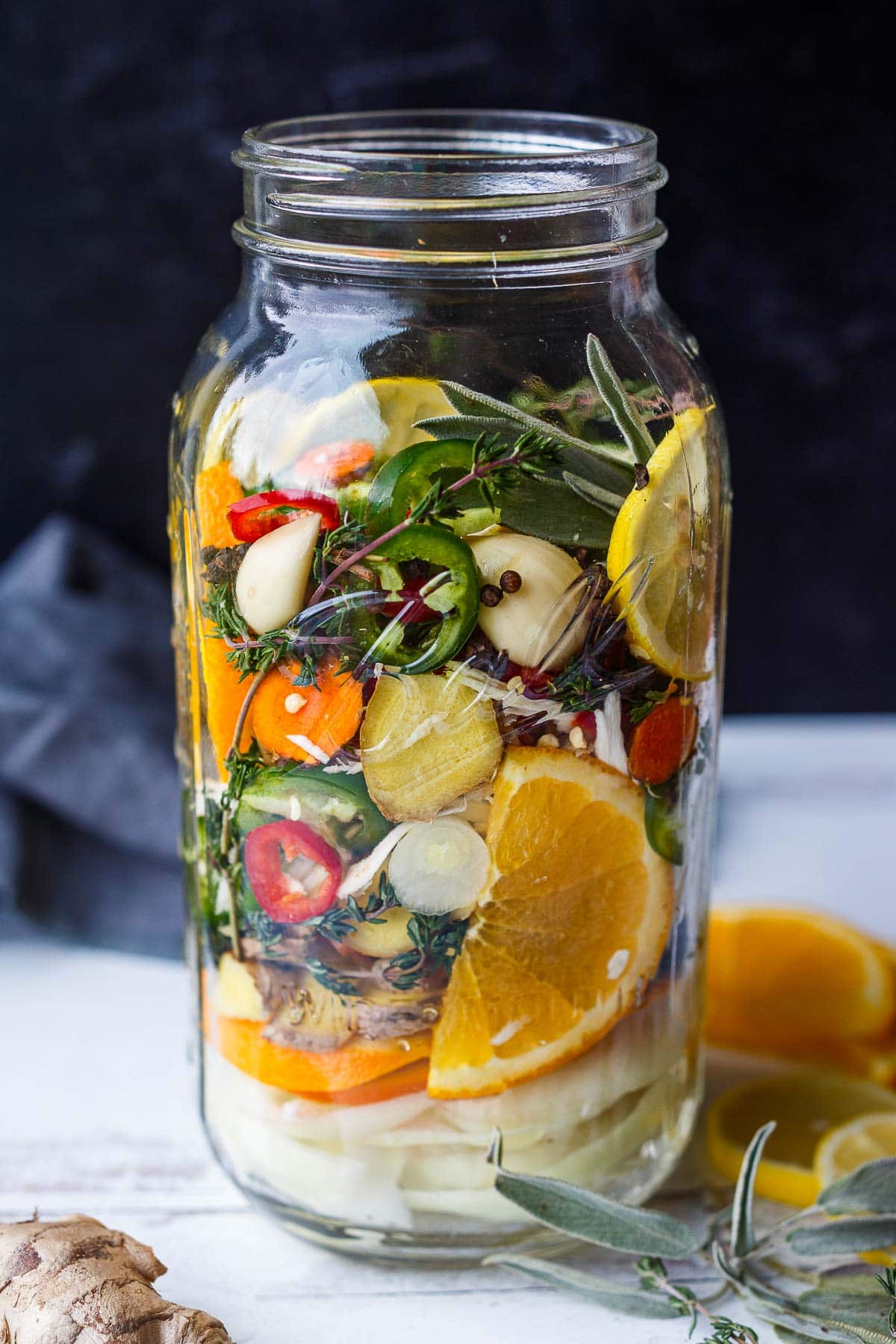 glass mason jar with ingredients for fire cider layered. 