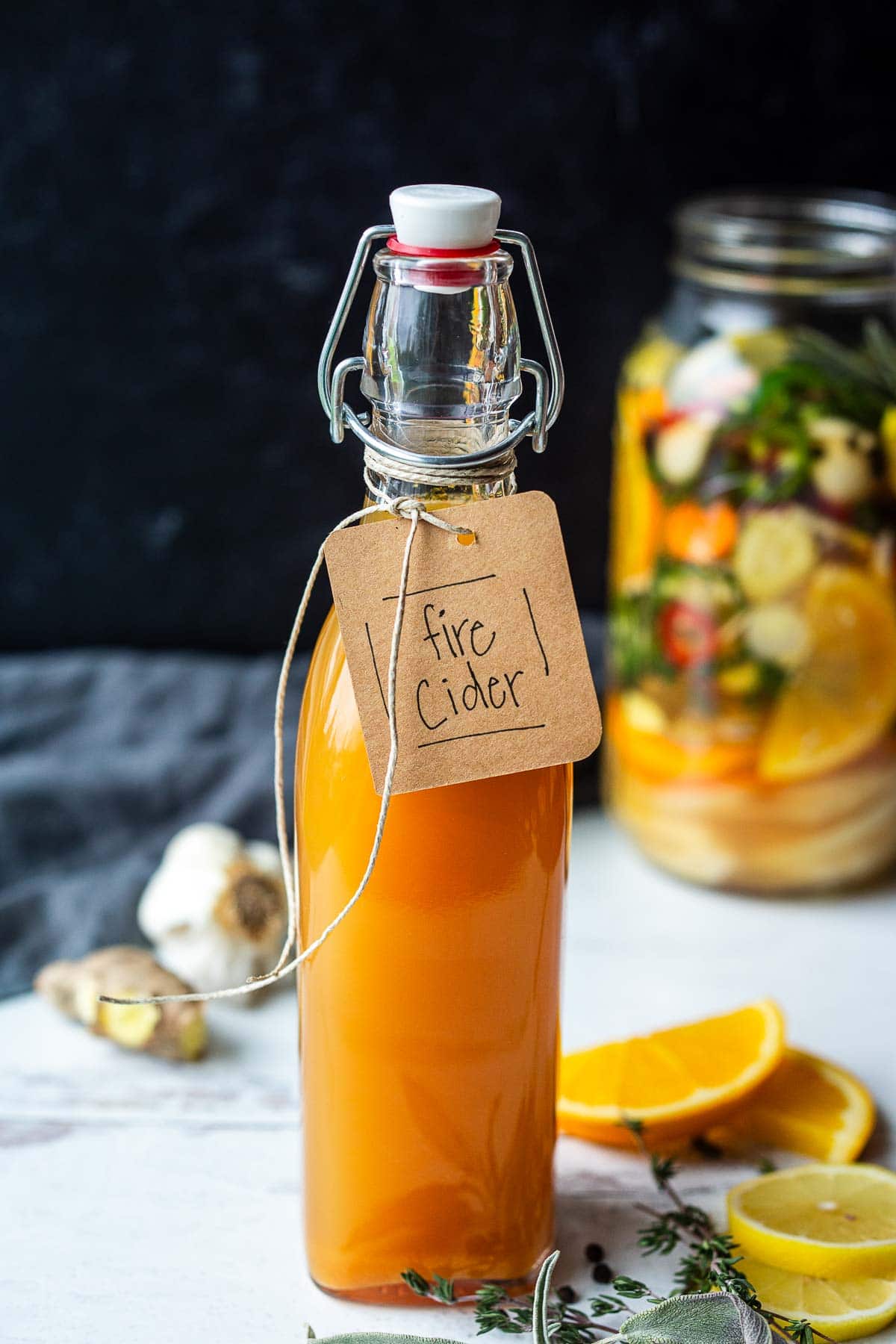glass jar with label that reads "fire cider" tied with twine. 