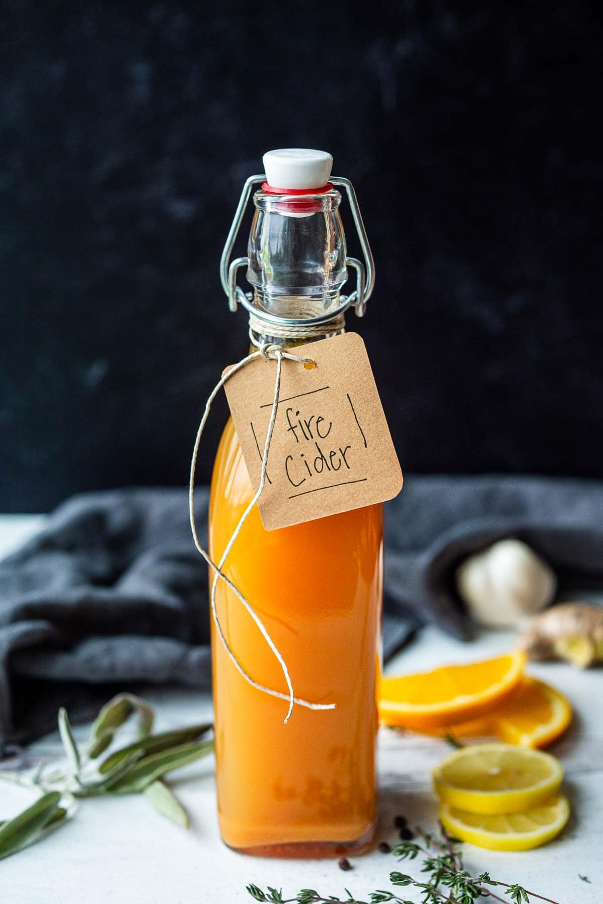 glass bottle of fire cider with brown paper label and twine. 