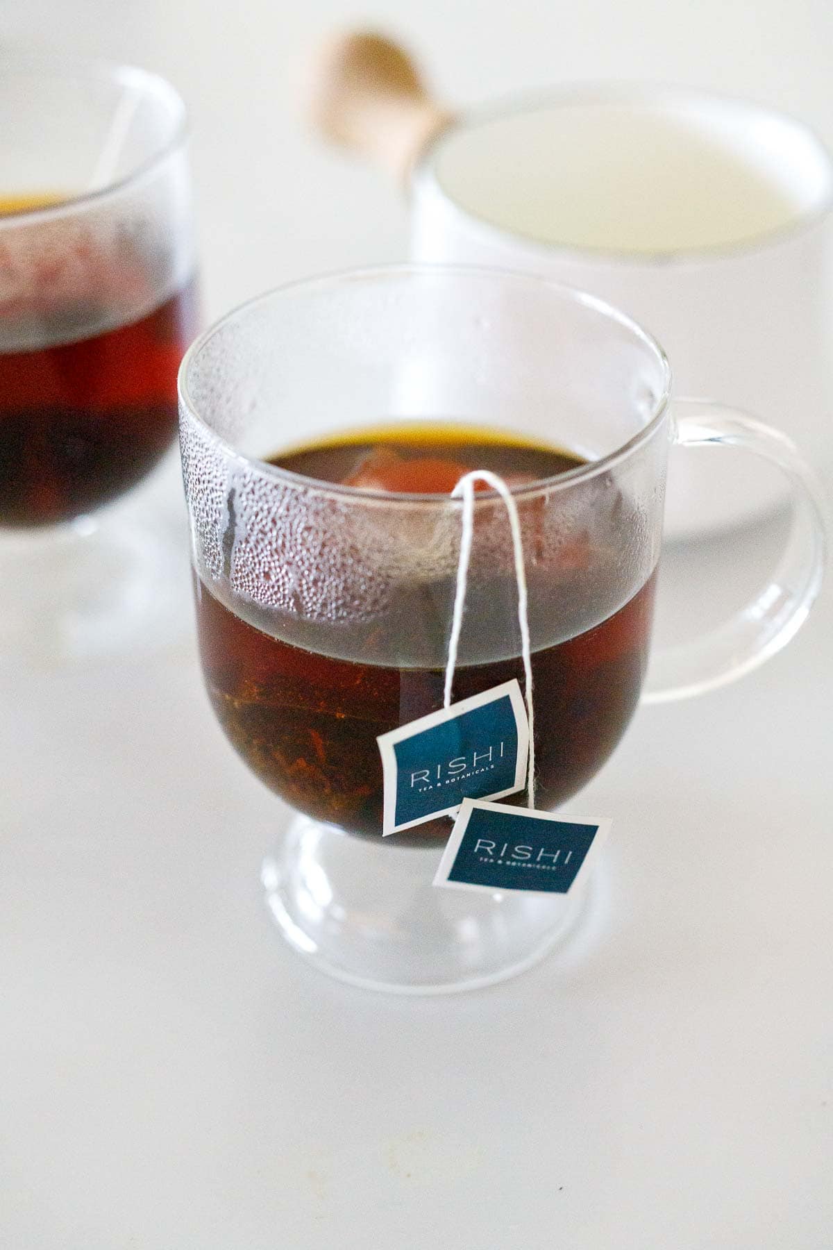 glass mug with two earl grey rishi tea bags steeping. 