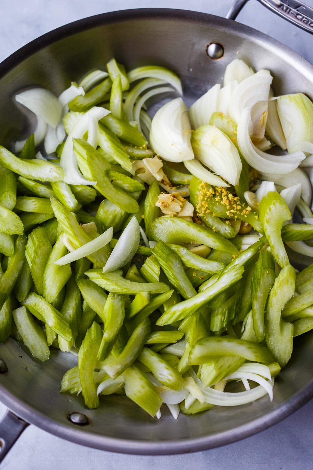 skillet with sliced celery and onions. 