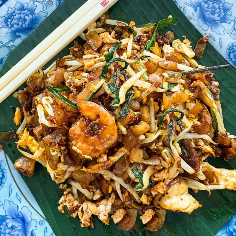 Learn how to make Char Kway Teow, an iconic Malaysian street food noodle dish with bold flavor that combines flat rice noodles stir-fried with a delicious mix of prawns, Chinese sausage, eggs, bean sprouts, and garlic chives.