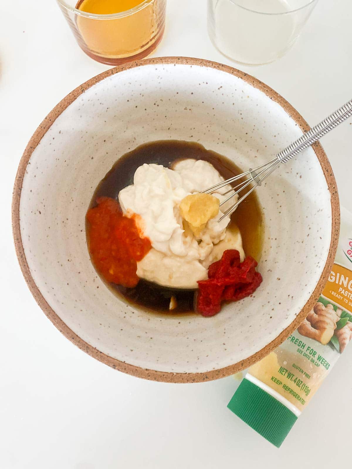 ceramic bowl with all ingredients for yum yum sauce and whisk.