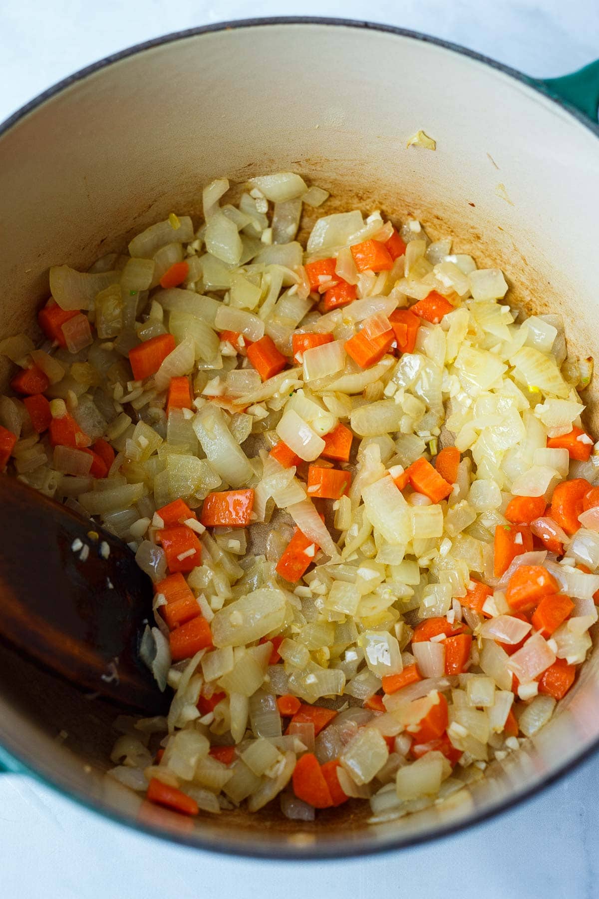 dutch oven with sautéing onions, carrots, and garlic.