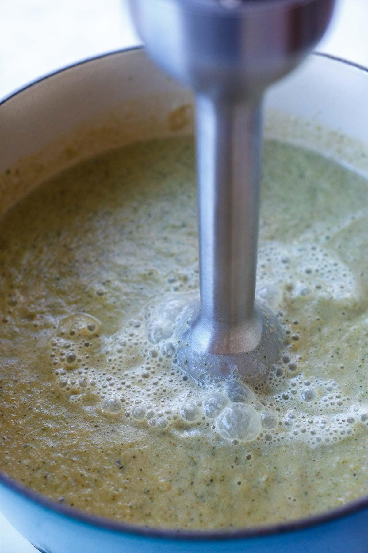 immersion blender blending broccoli cheddar soup.