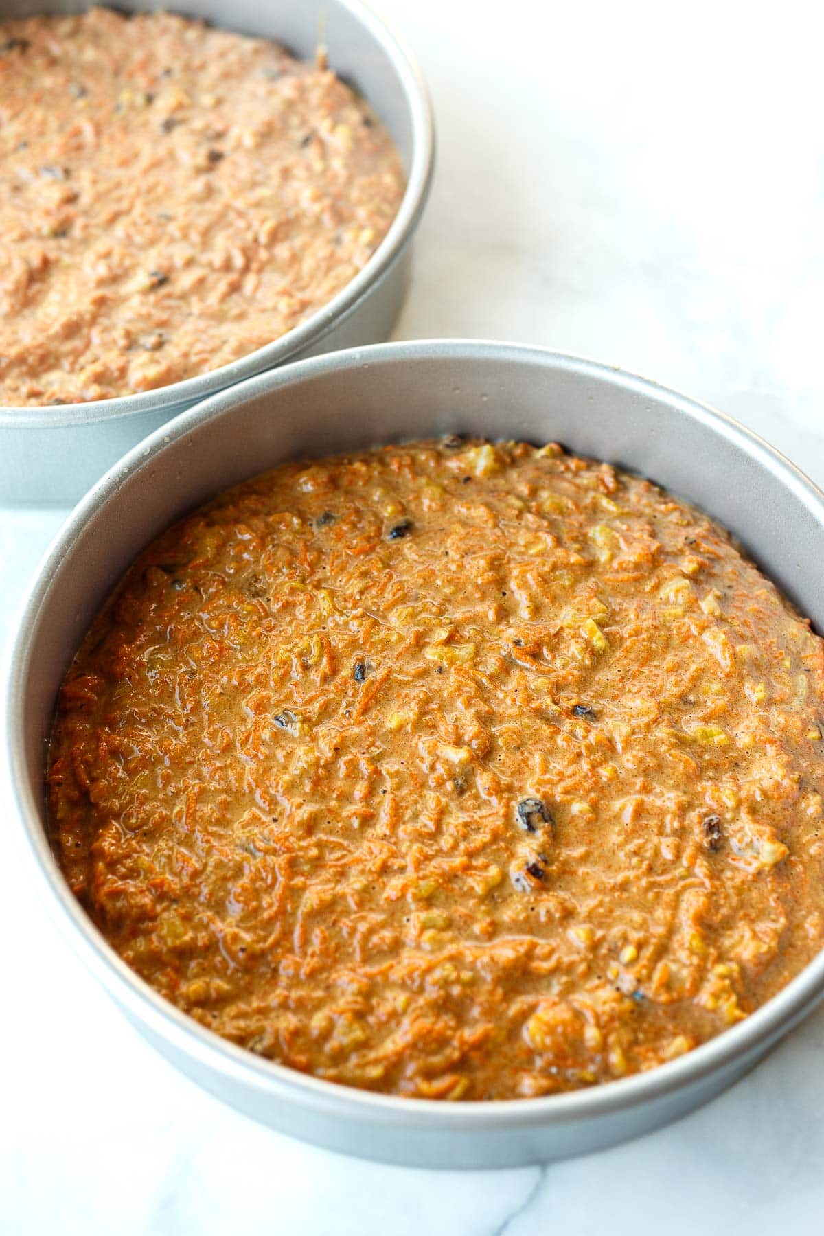 carrot cake batter in a round baking pan. 