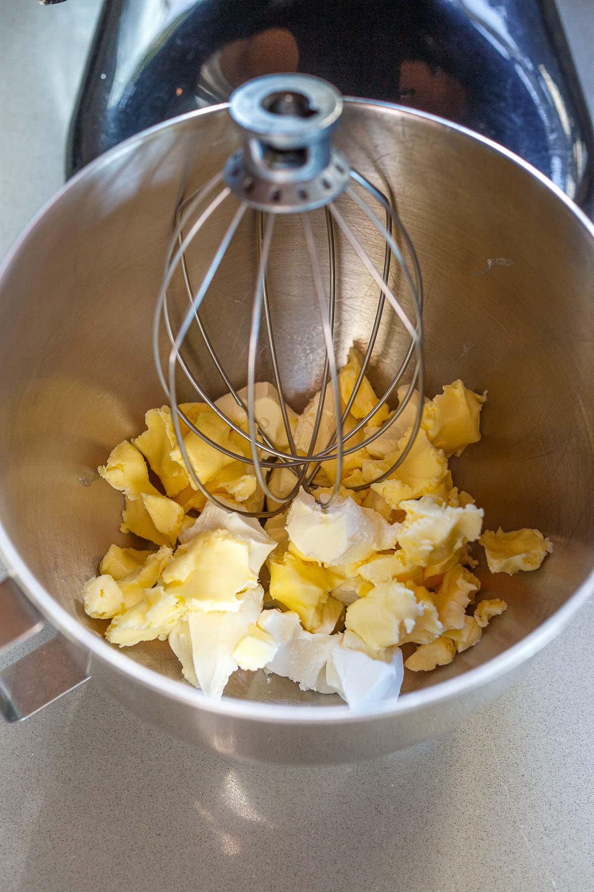 mixing bowl with room temperature butter and cream cheese in stand mixer with whisk. 