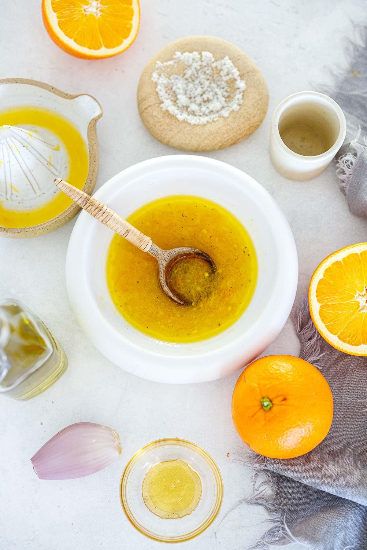 Citrus vinaigrette in a white bowl with orange juice.