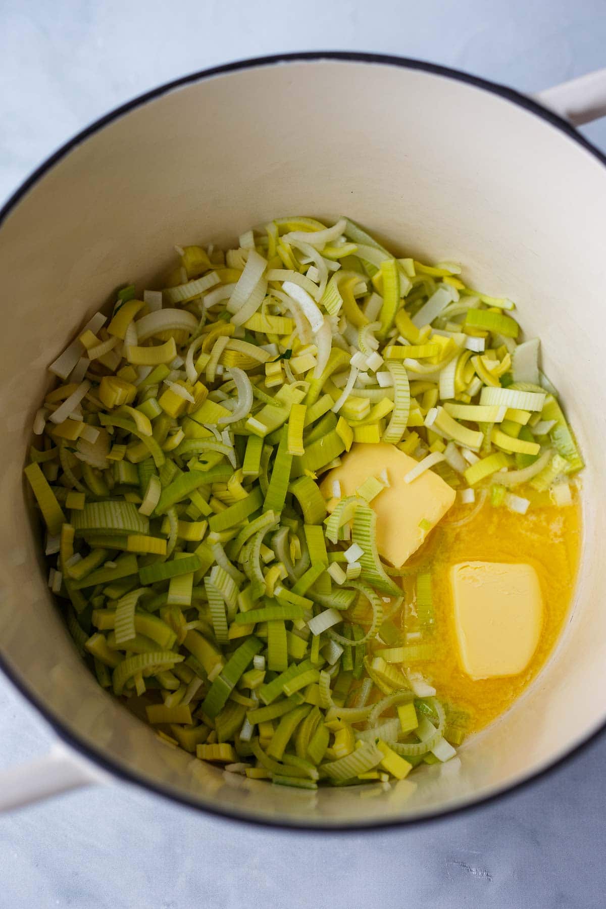dutch oven with leeks and butter beginning to melt.