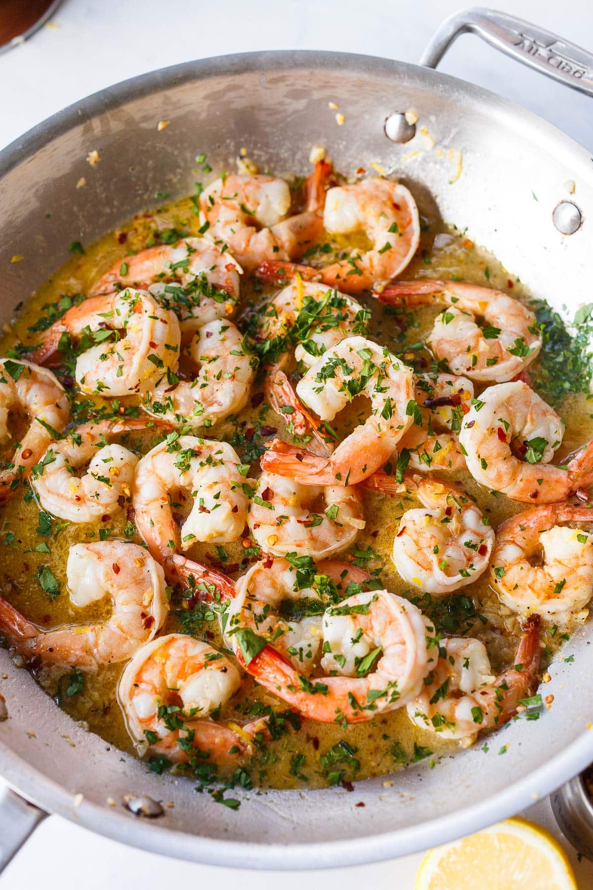 cooked shrimp scampi in skillet with fresh minced parsley.