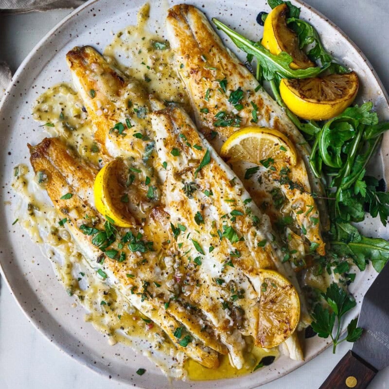 This easy branzino recipe is simply seasoned, pan-seared to perfection with crispy skin, and drizzled with a tangy lemon butter sauce.
