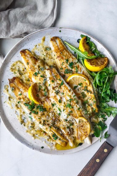 This easy branzino recipe is simply seasoned, pan-seared to perfection with crispy skin, and drizzled with a tangy lemon butter sauce.