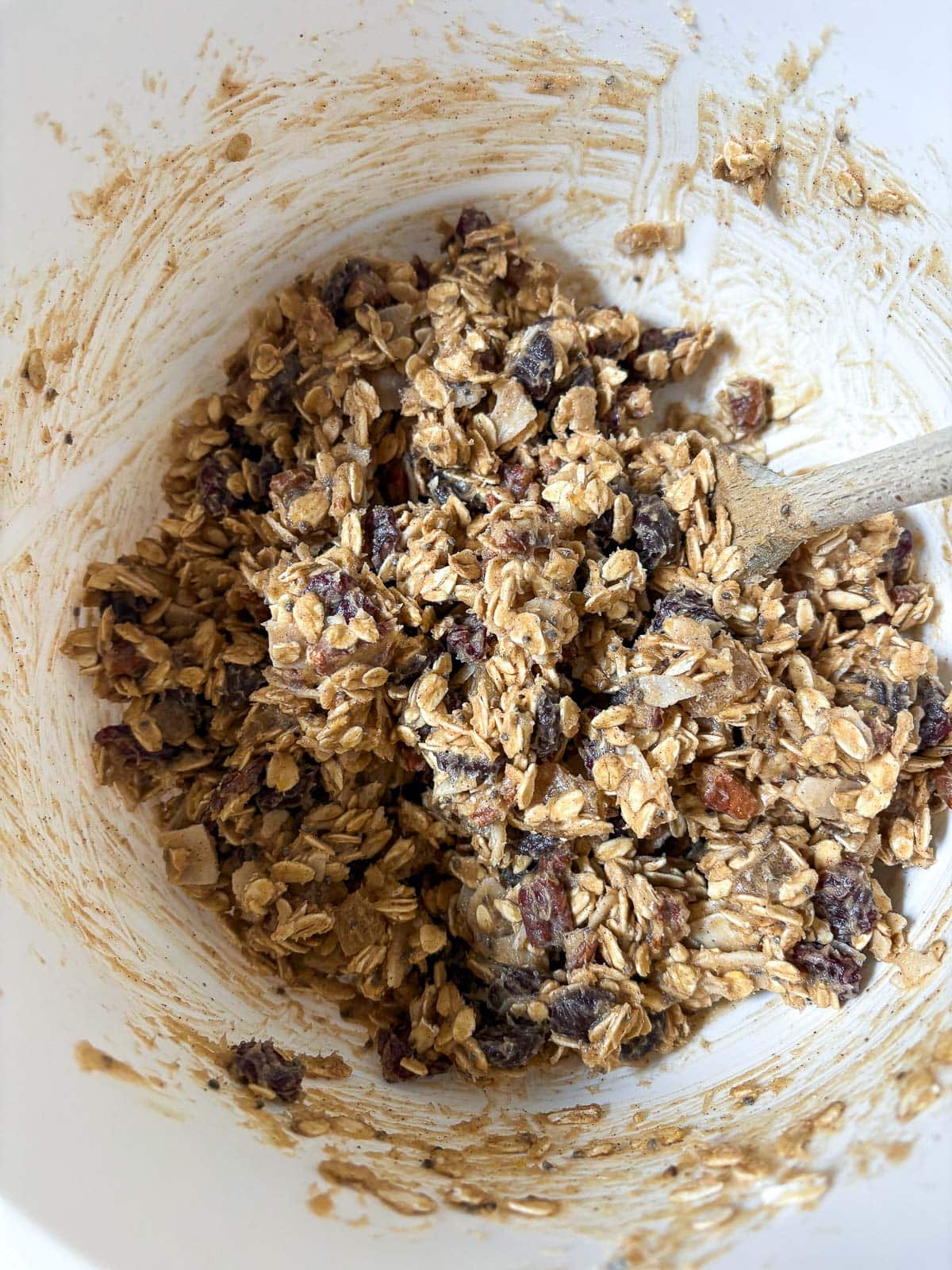 mixing bowl with cowgirl cookies batter and a wooden spoon to mix.