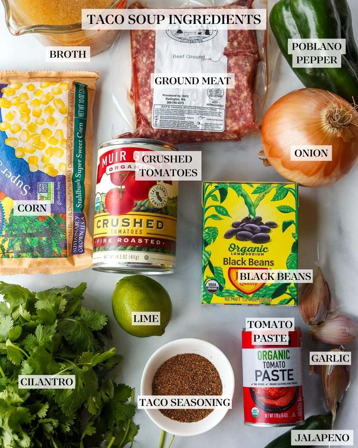 Ingredients in Taco Soup- corn, ground beef, onion, poblano pepper, crushed tomatoes, broth, black beans, lime, garlic, cilantro and tomato paste. 