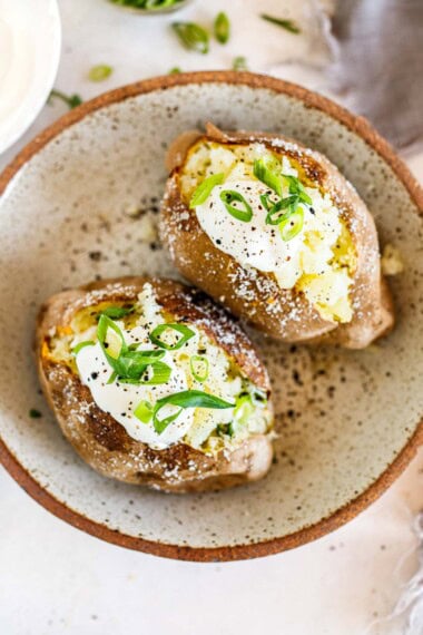 Learn how to bake a potato like a pro! This easy baked potato recipe yields perfectly fluffy insides with a deliciously crispy skin. All you need are russet potatoes, salt, and olive oil—and the olive oil is optional too.