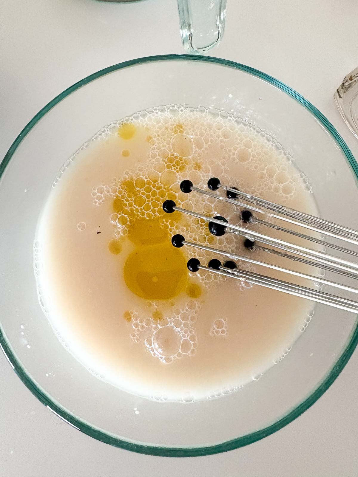 whisk mixing oil with yeast mixture.