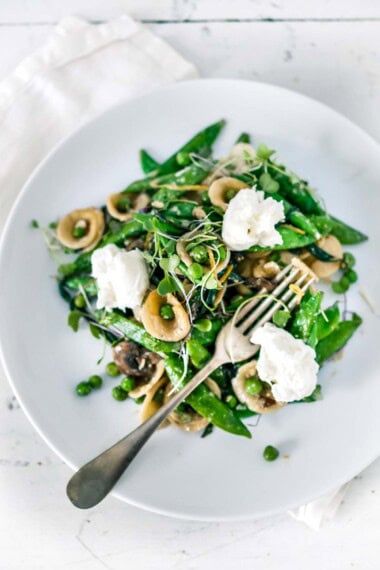 Spring Orecchiette Pasta with asparagus, mushrooms, peas and fresh herbs in a light carbonara sauce with dollops of creamy Burrata cheese.
