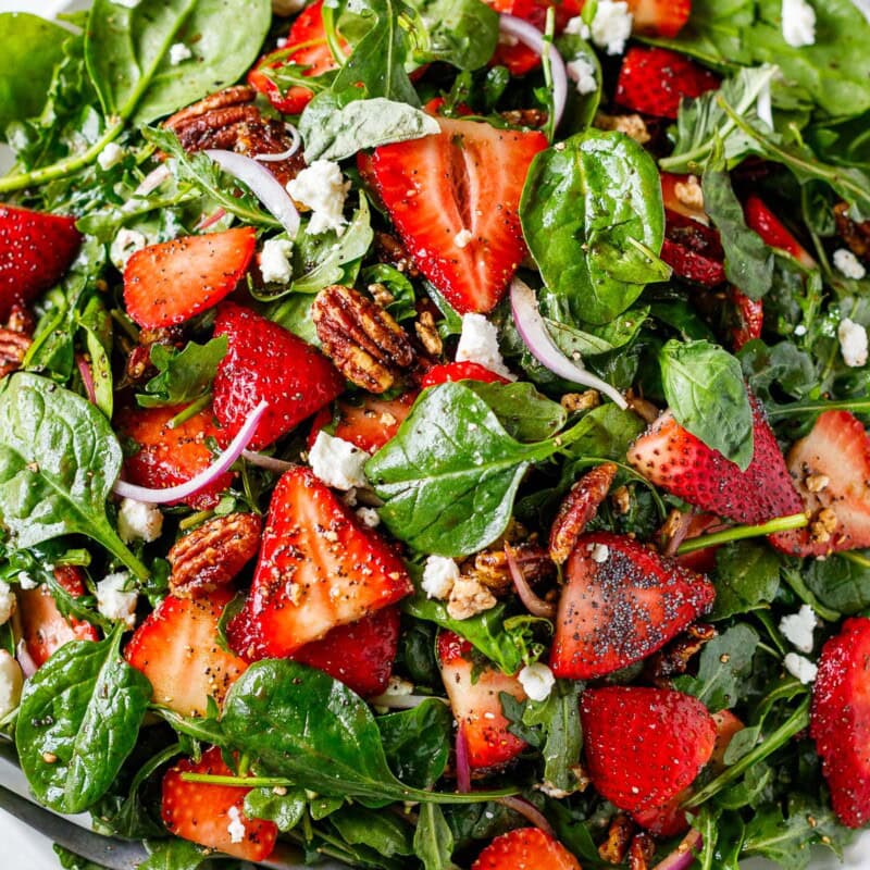 This Strawberry Spinach Salad with vanilla balsamic poppy seed dressing, pecan brittle, basil, and goat cheese is healthy, delicious, and such a crowd pleaser!