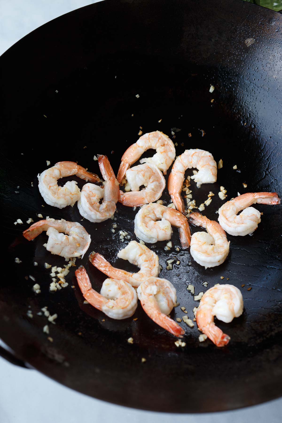Shrimp and garlic frying in a wok.