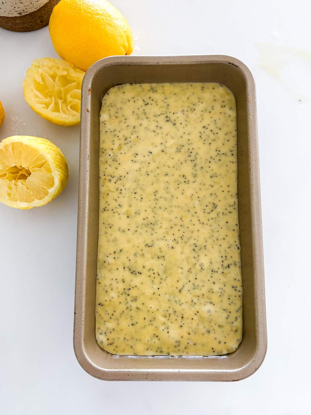 lemon poppy seed cake batter in a loaf pan. 