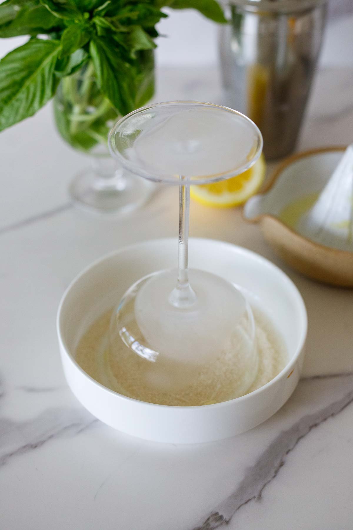 turning coupe glass upside down in small dish with sugar. 