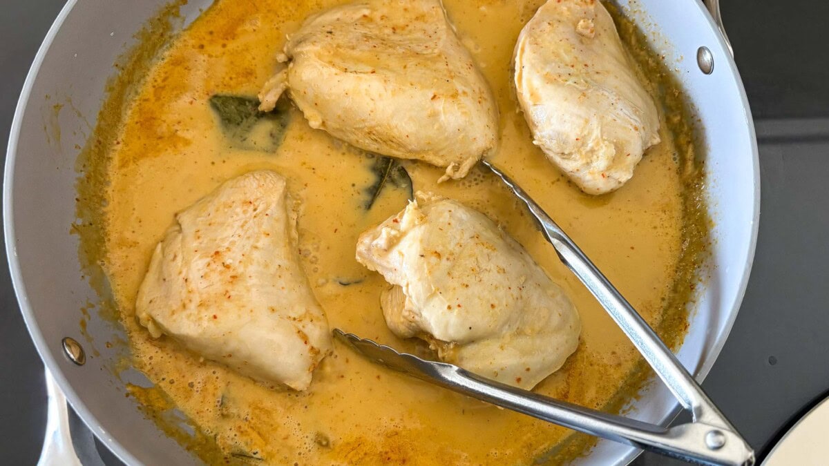 poaching the chicken in the coconut milk.
