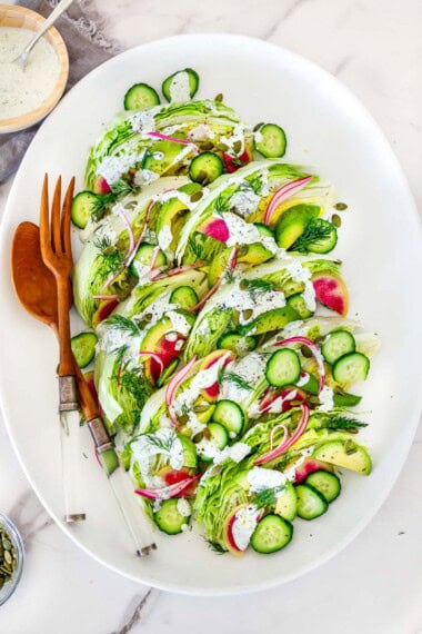 This easy wedge salad platter is perfect for summer entertaining! Made with crisp iceberg lettuce, creamy dill ranch, and fresh veggies, it’s affordable, make-ahead friendly, and serves 8—ideal for outdoor gatherings or potlucks.