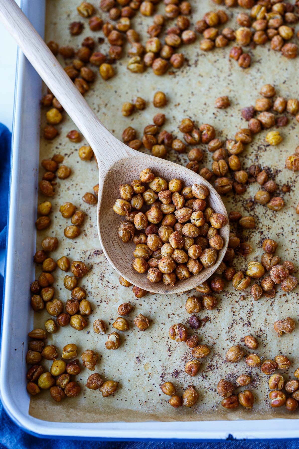 crispy chickpeas on a sheet pan with a wood spoon.